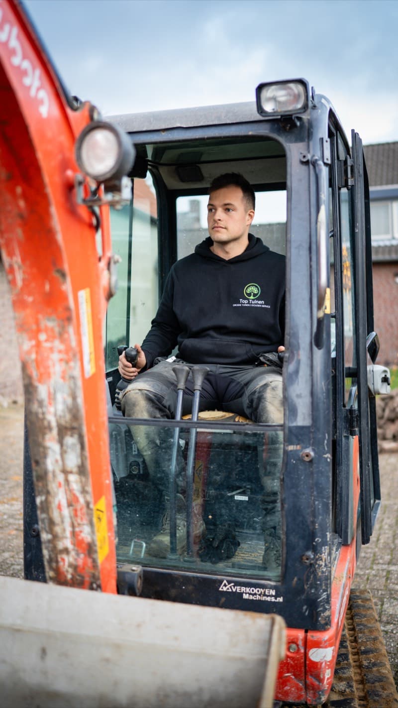 Top Tuinen medewerker in de Kubota graafmachine